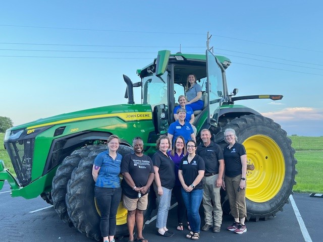 a group of people standing in front of a tractor