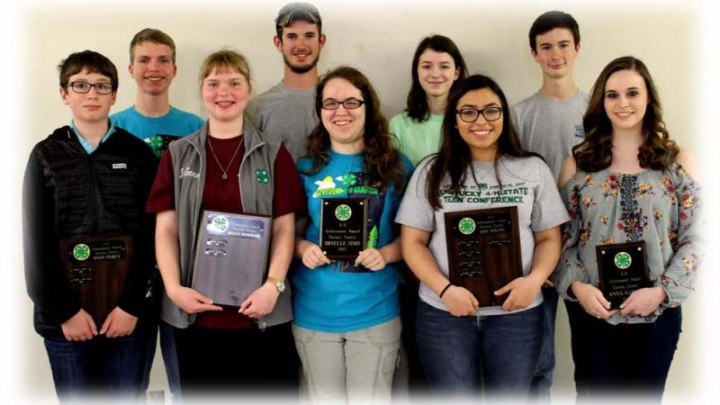 group of 9 teens holding plaques